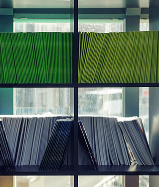 an image of a bookshelf with lots of colorful folders on its shelves to represent our County Recording & Retrieval Services