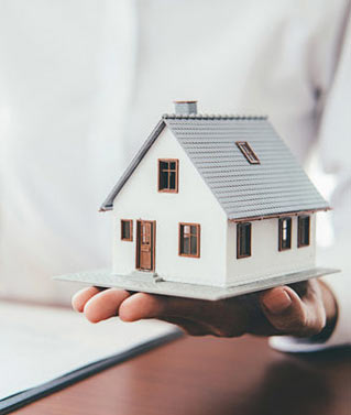 an image of a person holding a model of a house to represent our real property services