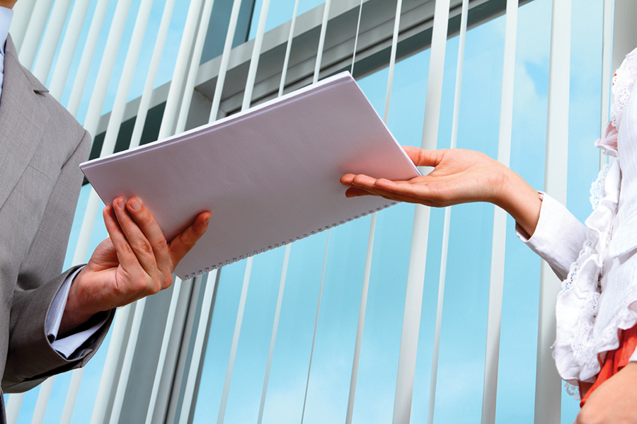 Image of woman handing man paperwork to represent a registered agent delivering SOP