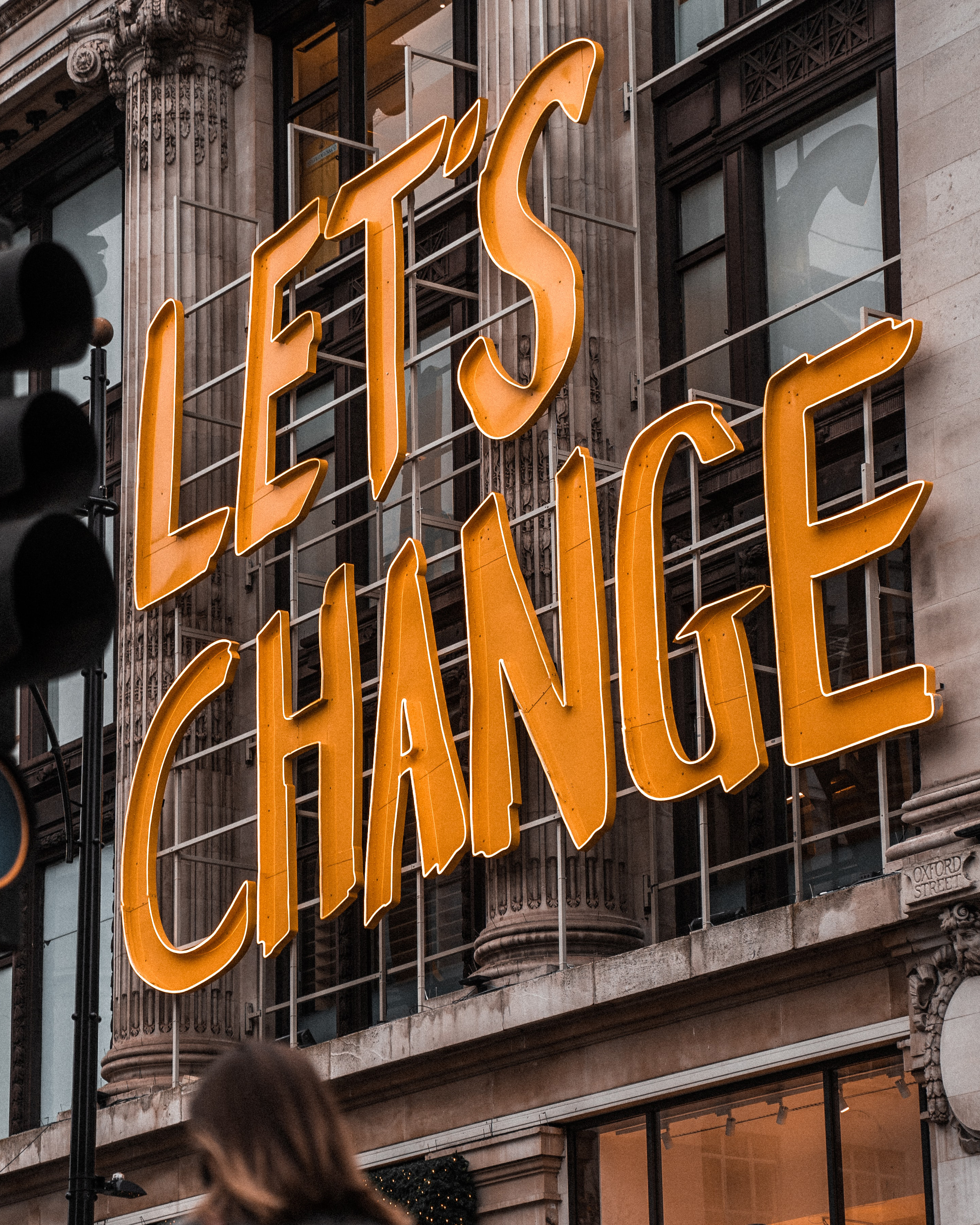 A sign on the side of a building that says "Let's Change" to represent changing your registered agent.