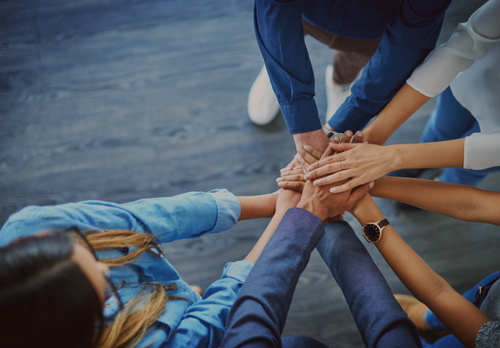 Business professionals sticking hands in to represent Parasec's culture and our Entity Formation and Compliance Experts